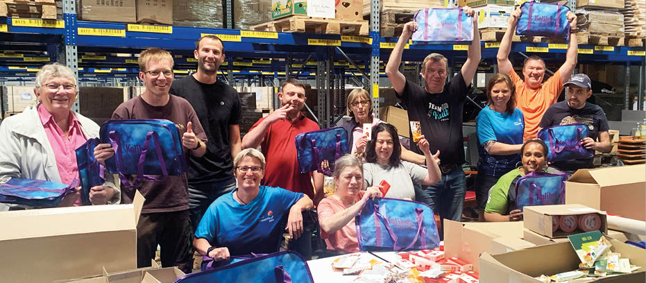 A group of people holding bags in a warehouse. Beschreibung von KI generiert