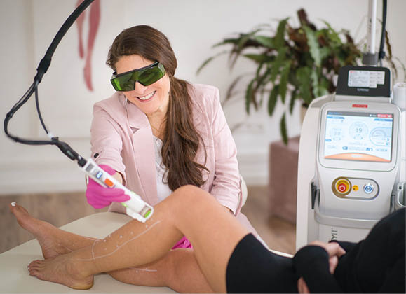 A woman is getting her legs done with a machine. Beschreibung von KI generiert