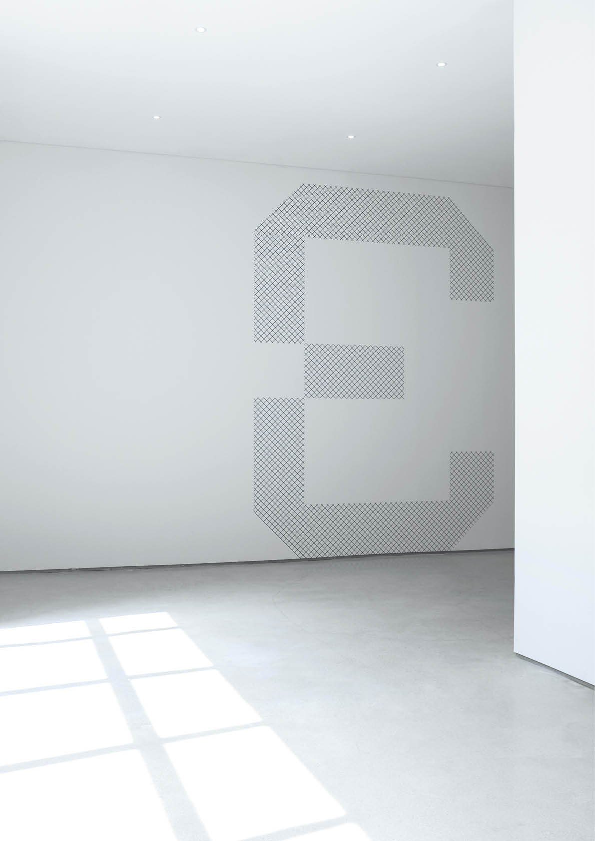 A large number three made up of small black diagonal lines is displayed on a white wall in a bright, minimalist room with sunlight streaming through a window. Beschreibung von KI generiert