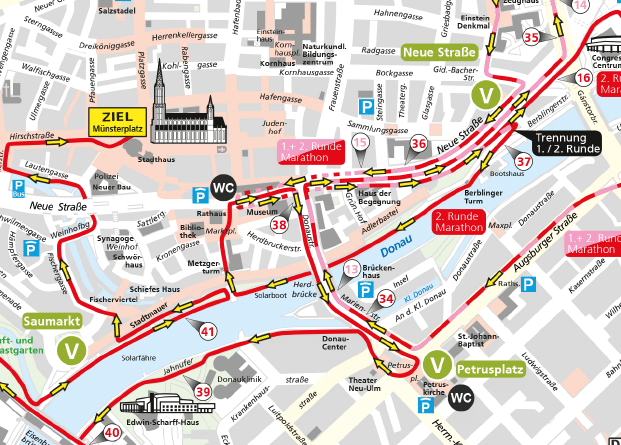 A detailed city map showing a marked route along the Danube River with labeled streets, bridges, landmarks, and public transportation stops in the Neu-Ulm area. Beschreibung von KI generiert