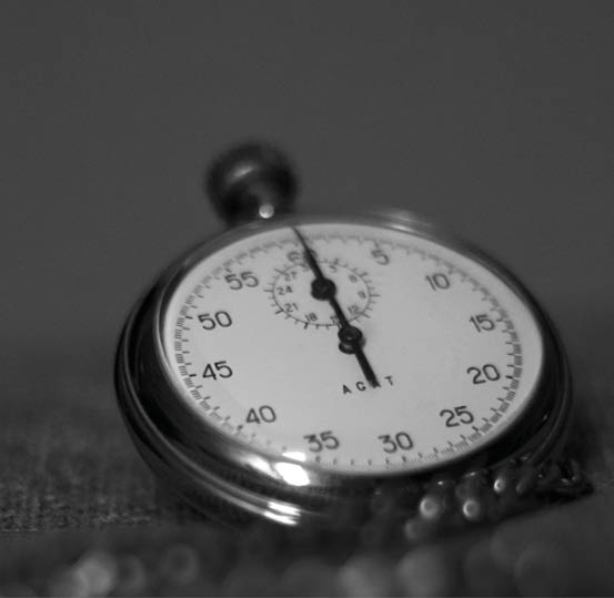 A close-up black and white photograph of a vintage stopwatch resting on a textured surface. Beschreibung von KI generiert